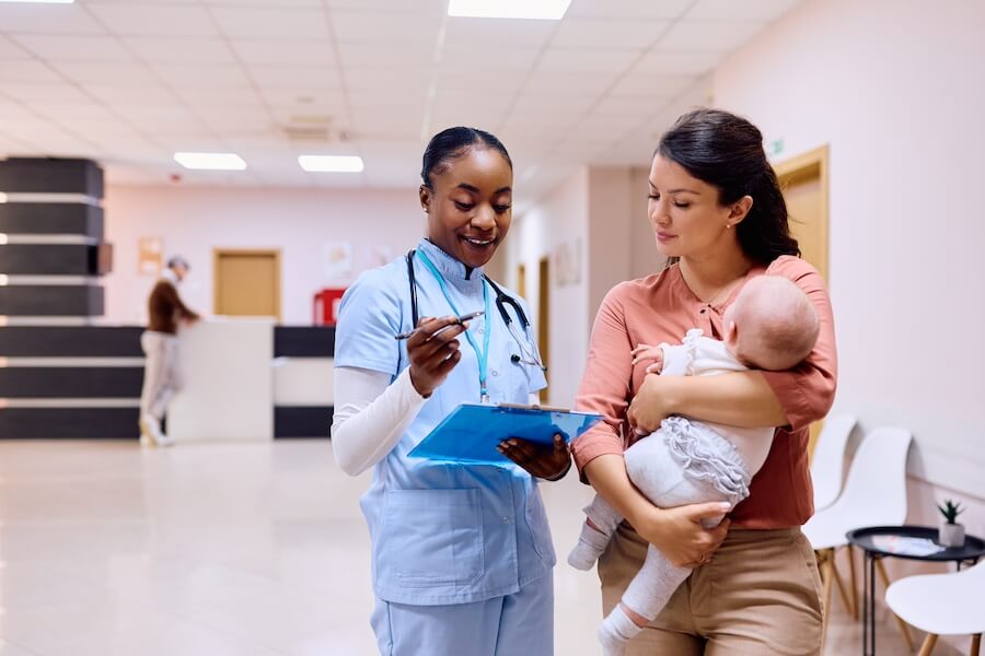 happy mother with baby talking to pediatric nurse 2023 11 27 05 22 04 utc