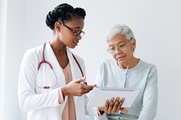 A healthcare professional reviews care information with an adult patient.